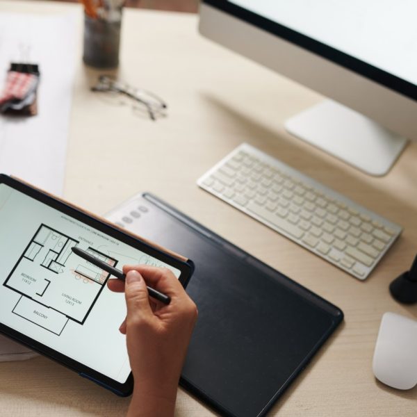 Closeup image of architect checking plan of house floor on tablet computer
